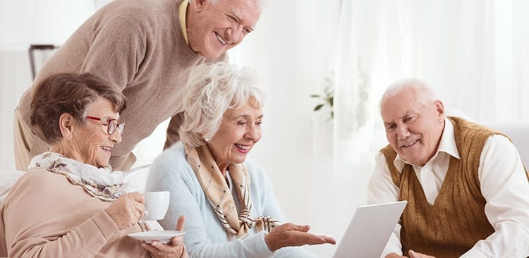 Elderly men and woman looking at laptop