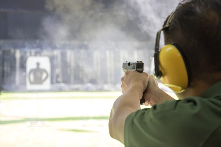 Image of man wearing protective hearing gear at shooting range